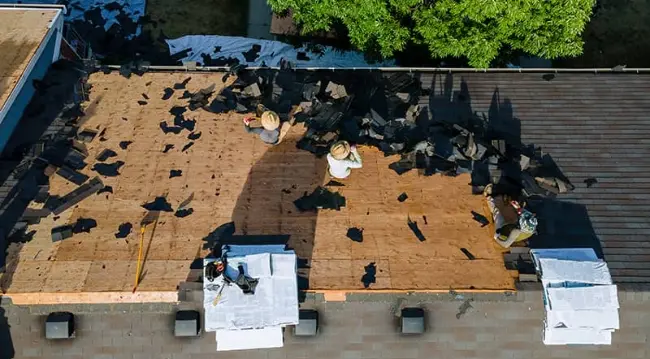 A storm damaged commercial roof being replaced by a West Orange Roofing crew